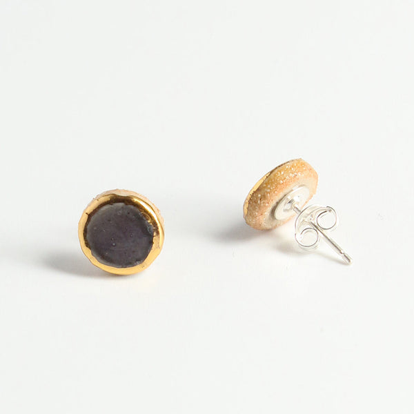 Two gold and purple earrings on a white background