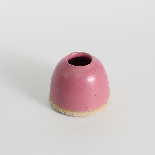 fuchsia ceramic vase on a light grey background