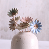Handmade soft pastel glaze ceramic daisy flower stems displayed in an off-white vase.