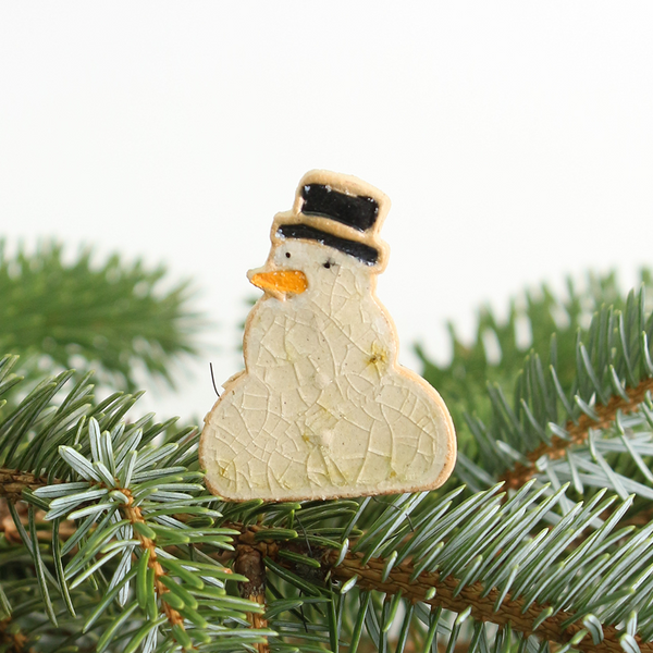 Decorative snowman plant hugger on a Christmas tree branch