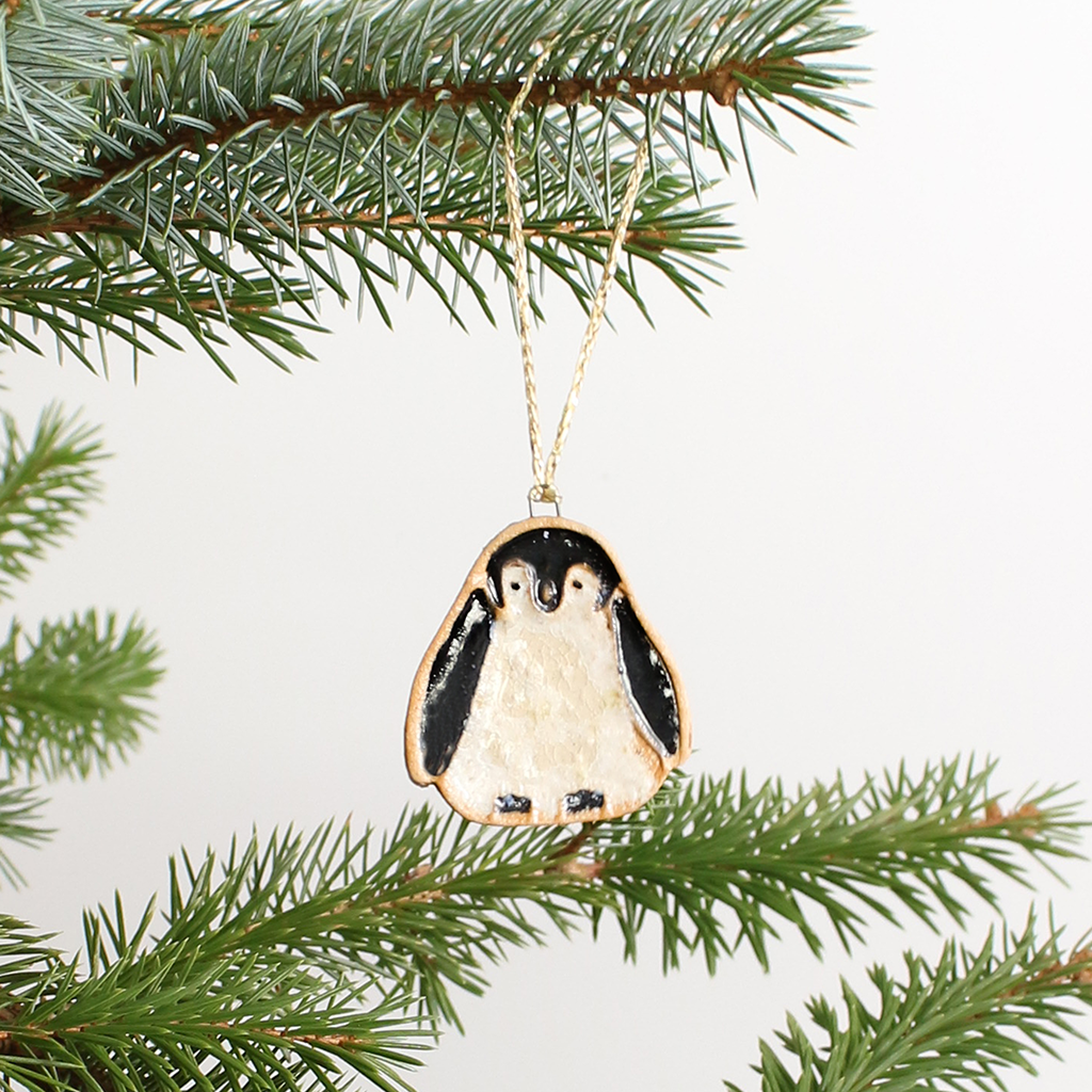 Ceramic Penguin Christmas ornament hanging on a tree branch