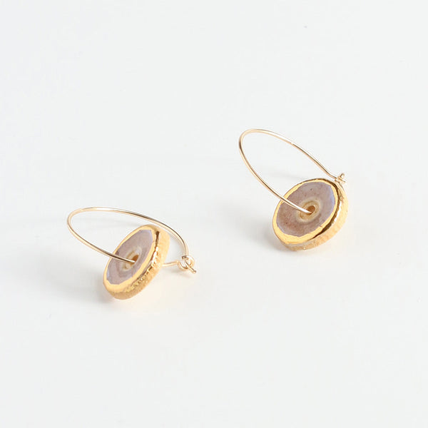 Gold hoop earrings with circular stone accents on a white background