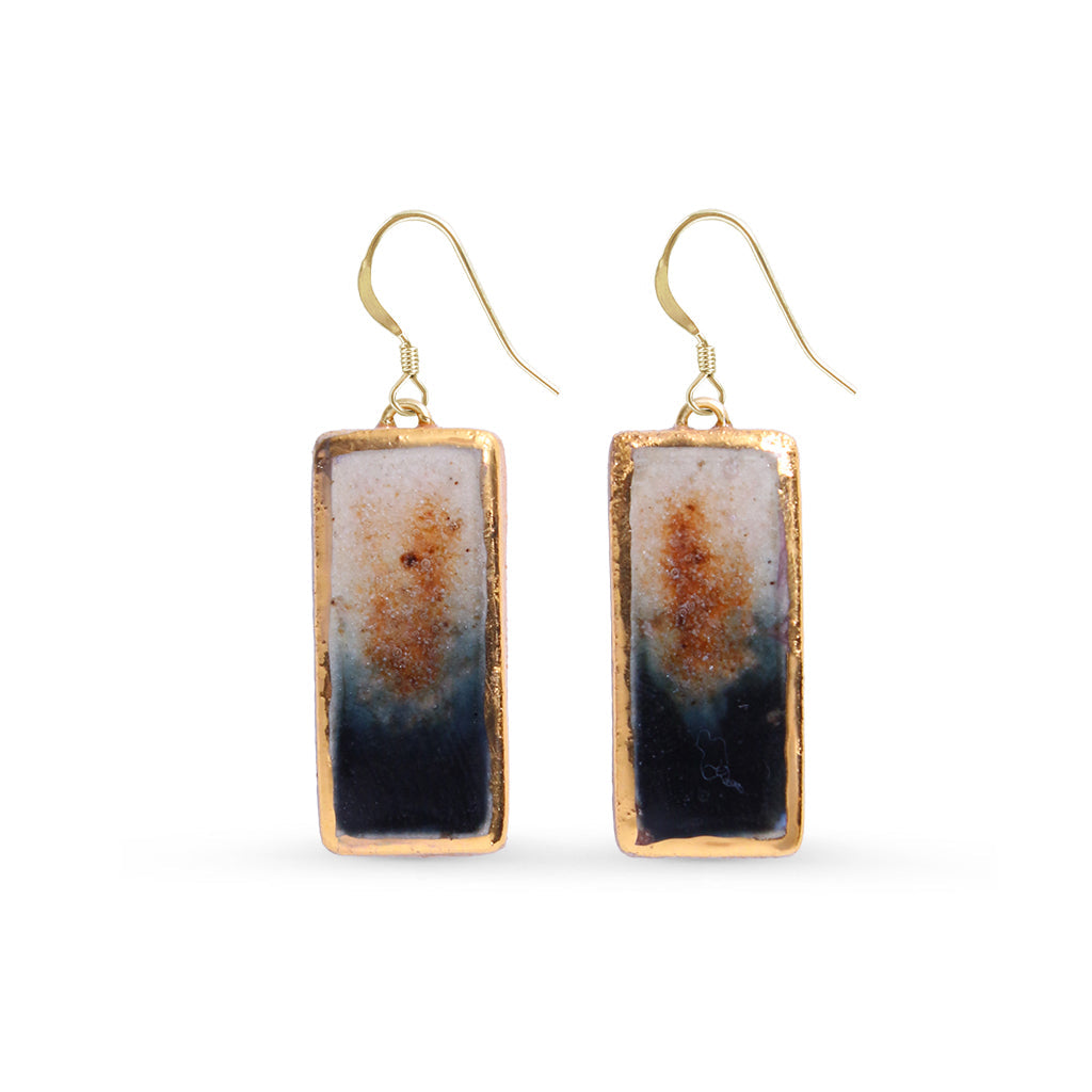 Rectangular earrings with gold lustre and eclipse colours on a light gray background