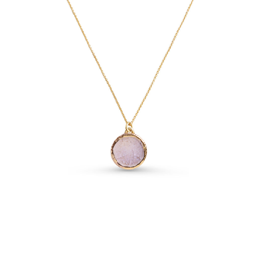 Small Dawn pendant with a gold chain against a white background. The ceramic pendant features pale pink glass and gold lustre detailing around the edge of the pendant. 