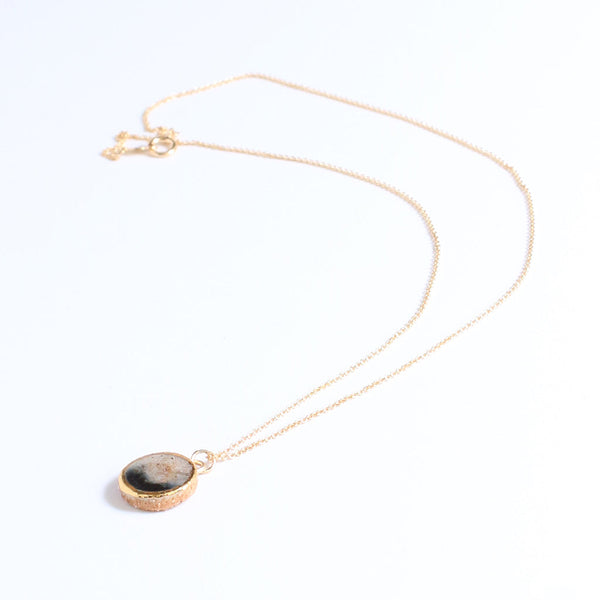 Gold necklace with a pendant on a white background