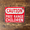 Red and white 'Caution: Free Range Children' sign on a wooden background