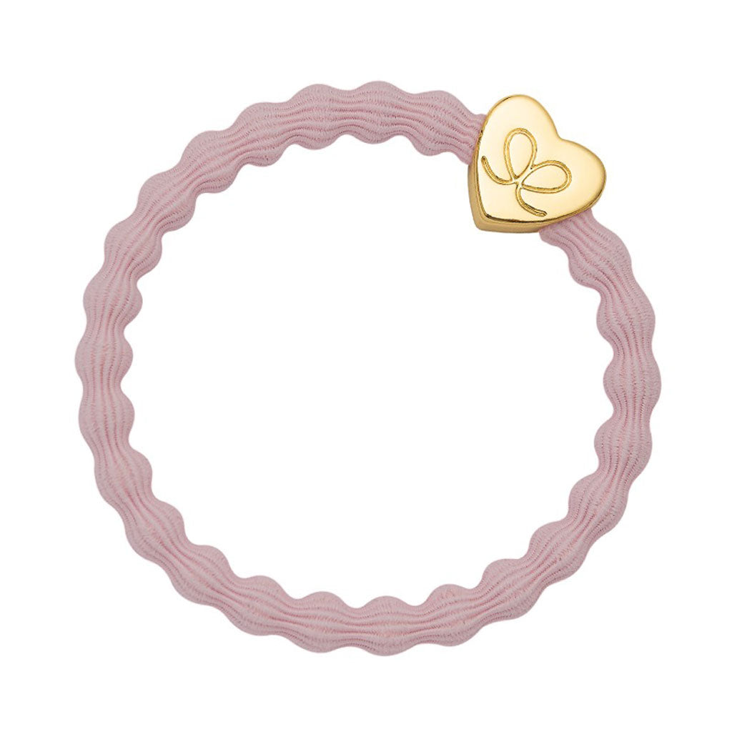 Bracelet élastique en forme de cœur doré sur rose tendre